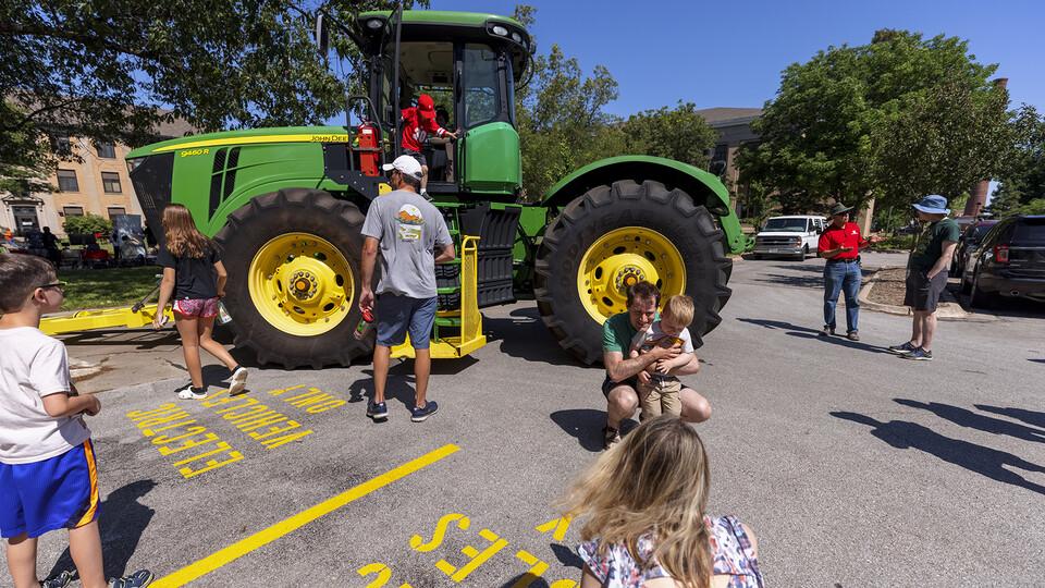 People gathered around a tractor at East Campus Discovery Days and Farmer's Market.